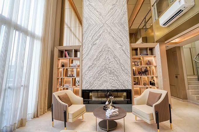 Double-height living room with marble feature wall and fireplace